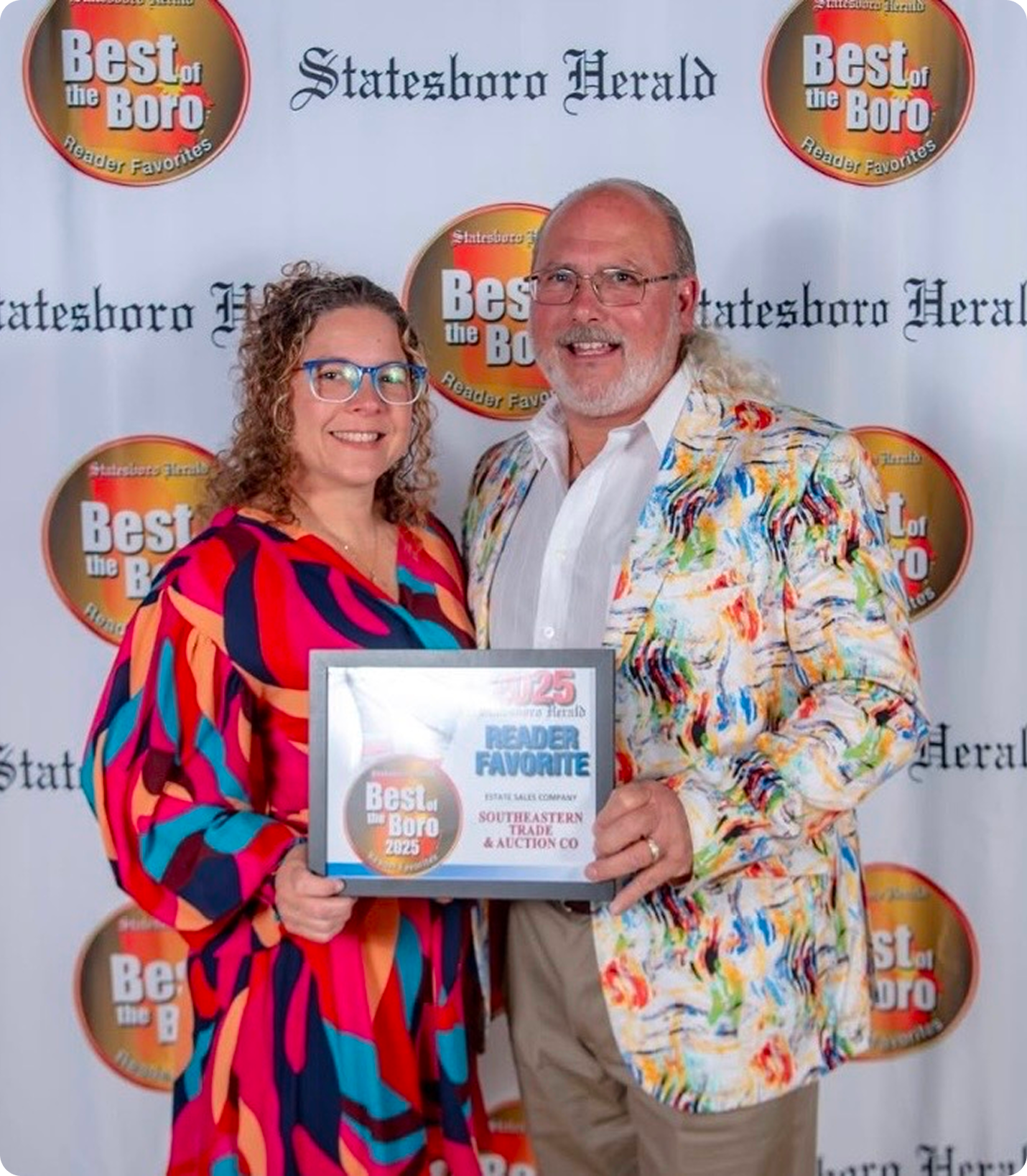 Two people holding a "Best of Boro" award.