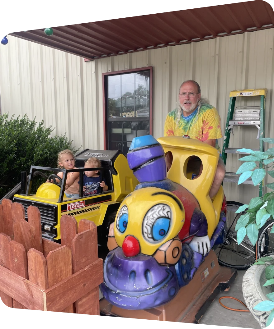 Man and children on amusement ride vehicles.